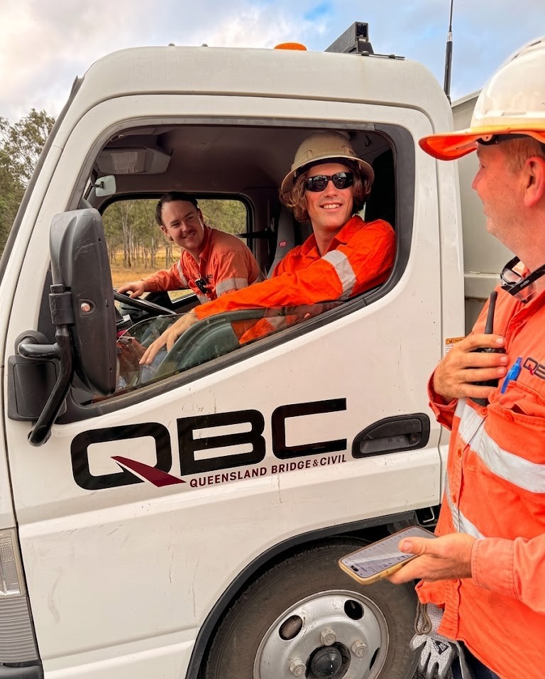 QBC supervisor and operators in workwear communicating on site - collaborative delivery in action